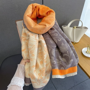 Detail of color-block scarf with paisley print and soft decorative tassels on the edge