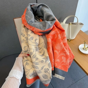 Detailed view of paisley patterns and soft tassels on a tricolor autumn shawl scarf