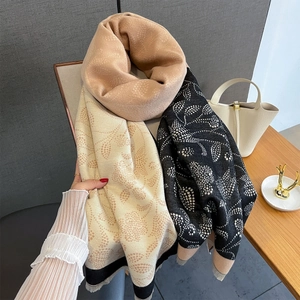 Detail of tricolor paisley scarf showing khaki, beige, and black patches with fringe