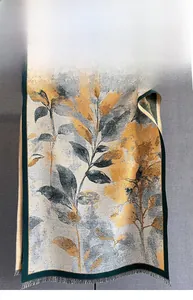 Détail d'un châle pashmina à fleurs avec bords cousus vert foncé et pompons gris fins