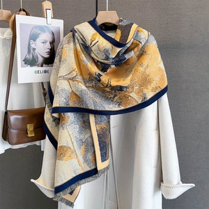 Détail d'un châle effet cachemire à motif floral avec franges sur un manteau de laine