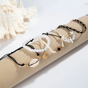 Detail of 5pcs boho beach bracelet set featuring shell charms and evil eye on display