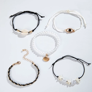 Detail view of beach style multi-layer bracelets featuring shell and evil eye charms