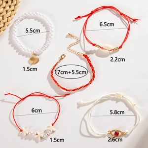 Detailed view of 5-piece beach style bracelet set with shells and evil eye charms