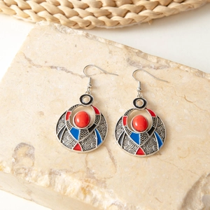 Detail of vintage bohemian silver drop earring with red gem and intricate carvings