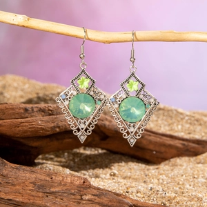 Detail view of bohemian hollow rhombus earrings with green gemstone and floral accent