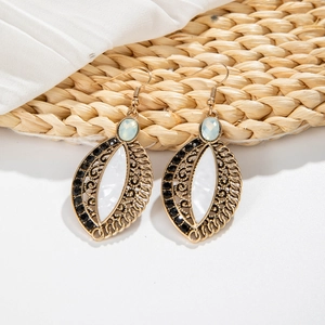 Detail of vintage bohemian dangle earrings with marble resin and blue gemstone accents