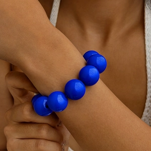 Detail of ethnic style bracelet with large polished royal blue beads on wrist