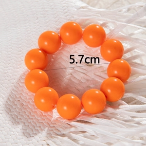 Detailed view of bright orange beaded bracelet with a 5.7cm diameter size measurement
