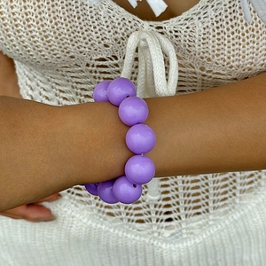 Ethnic style chunky purple beaded bracelet shown on a wrist for a casual bohemian look