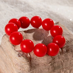 Macro shot of large polished red beads on a textured stone base for ethnic style bracelet
