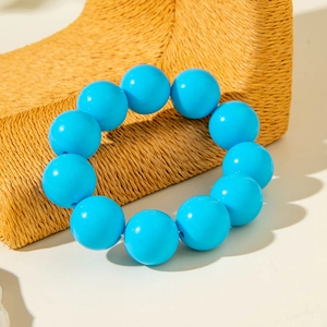 Macro detail of large glossy blue beads on a tribal style elastic bracelet for women