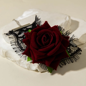 Macro shot of gothic black lace choker with deep red velvet rose and eyelash fringe