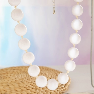 Detailed view of large translucent white beads on a bohemian ethnic style necklace