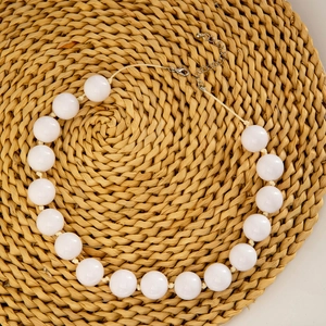 Close-up of white round oversized beads on a bohemian necklace with lobster clasp