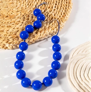 Close-up of bohemian style necklace featuring large polished deep blue beads and silver clasp