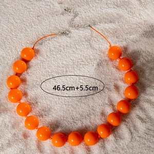 Detail of bohemian orange beaded necklace with lobster clasp and adjustable silver chain