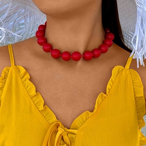 Close-up of bohemian bold red oversized beaded necklace worn by a fashion model