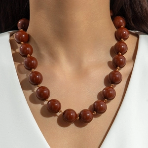 Close-up of bohemian chunky brown resin beads necklace with a high-gloss polished finish