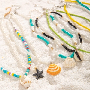 Colliers de perles bohèmes colorées avec pendentifs étoile de mer et coquillage sur sable