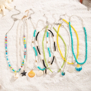 Colliers bohèmes en perles colorées avec pendentifs étoile de mer et coquillage sur sable