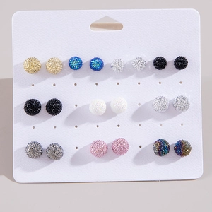 Dettaglio di un set di 9 paia di orecchini a sfera colorati con strass su base bianca