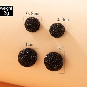 Dettaglio di orecchini a sfera neri da 0,8 cm e 1 cm con trama sfaccettata e peso di 3g