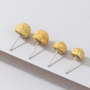 Dettaglio di quattro orecchini a lobo dorati a sfera con pavé di cristalli e perni argento