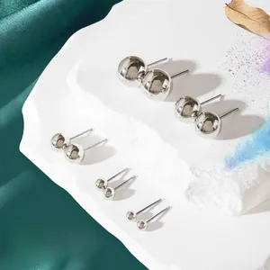 Set di cinque orecchini a sfera in argento lucido di varie dimensioni su pietra bianca