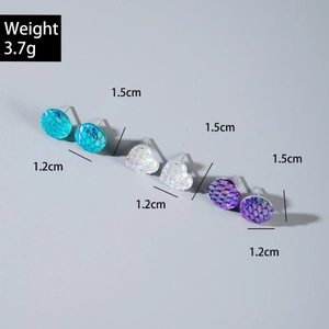 Dettaglio di orecchini colorati a perla tondi e a cuore con trama a scaglie e peso di 3,7g