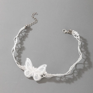 Détail du choker en dentelle blanche avec papillon brodé et fermoir argenté réglable