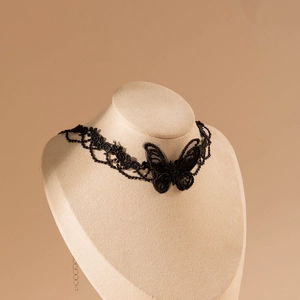 Détail du ras du cou en dentelle noire avec papillon brodé sur un buste d'exposition