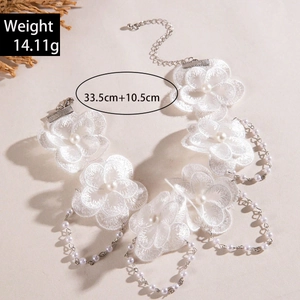 Détail du collier de fleurs en dentelle blanche avec perles et chaîne argentée bohème
