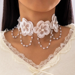Détail d'un choker en dentelle blanche avec fleurs brodées et perles délicates