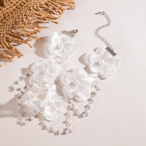 Détail du collier en dentelle blanche avec perles et chaîne à franges délicate