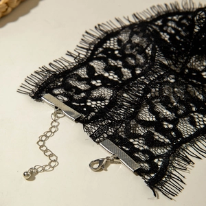 Détail d'un choker en dentelle noire montrant le fermoir mousqueton argenté et la chaîne
