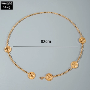 Detailed view of golden quilted round pendants on a metallic beach body waist chain