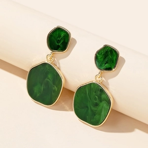 Detail of vintage irregular green marble earrings with polished gold metal framing