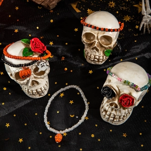 Dettaglio gioielli di Halloween con perline e ciondoli fantasma su un teschio
