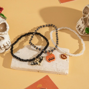 Dettaglio di braccialetti di perline per Halloween con ciondoli a forma di zucca e pipistrello