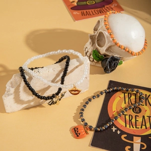 Dettaglio di cavigliere con perline per Halloween con ciondoli a zucca, pipistrello e teschio