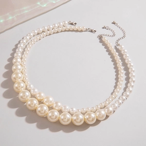 Détail d'un collier de perles dégradé double couche avec fermoir mousqueton argenté et chaîne
