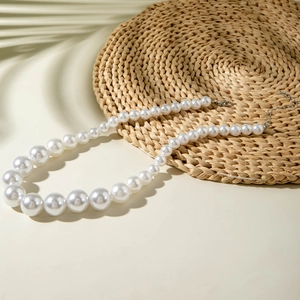 Vue détaillée d'un collier de perles dégradées avec fermoir sur un tapis tressé