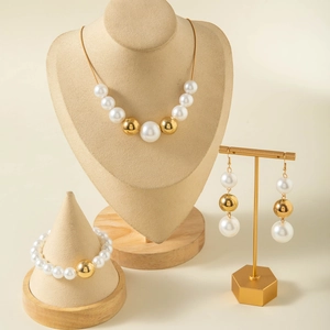 Vue détaillée d'un ensemble de bijoux élégants en perles et perles dorées avec collier