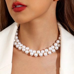 Gros plan du collier de perles tressé à deux rangs avec détails dorés sur un mannequin