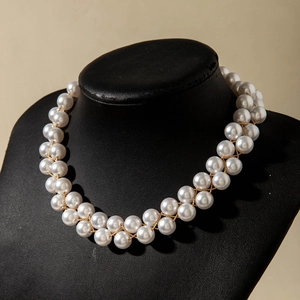 Vue détaillée du collier double rang de perles nacrées et fils dorés sur buste noir