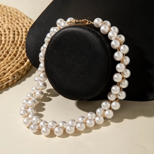 Détail d'un collier de perles double rang avec fermoir doré sur support noir