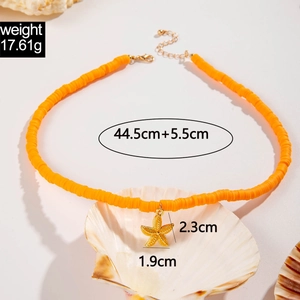 Detail view of bohemian orange beaded necklace with a textured golden starfish pendant