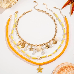 Close-up of bohemian layered shell necklace with starfish charms and pearls on white