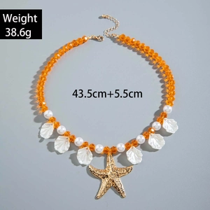 Detail of bohemian necklace with orange crystals, pearls, shells and starfish pendant